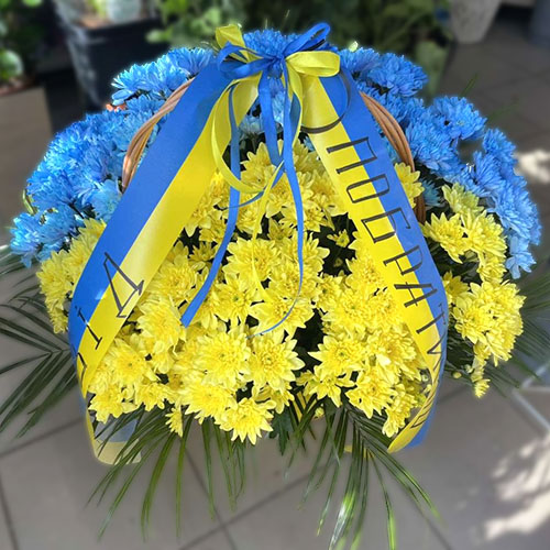 сині та жовті хризантеми в жалобному кошику фото